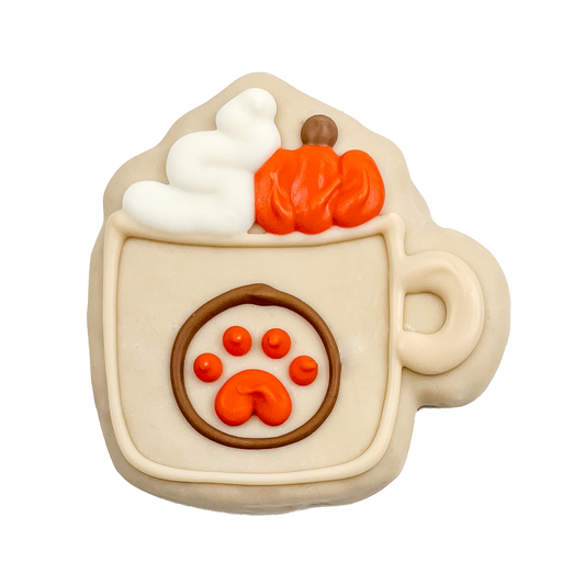 Decorative cookie shaped like a hot chocolate mug with pumpkins and a paw print on a white background